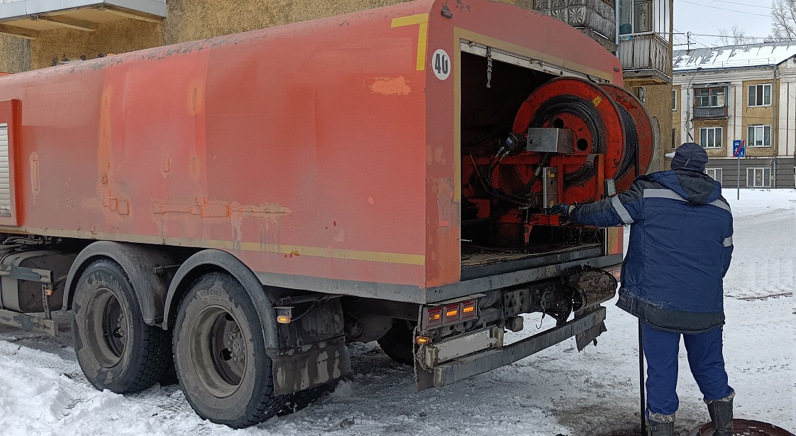 Каналопромывочная машина и работник прочищают засор в канализационной системе в Новоуральске