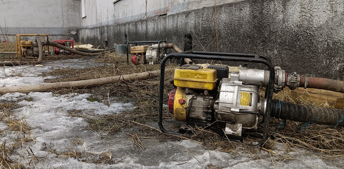 Откачка мотопомпами талой воды из подвала дома в Среднеуральске